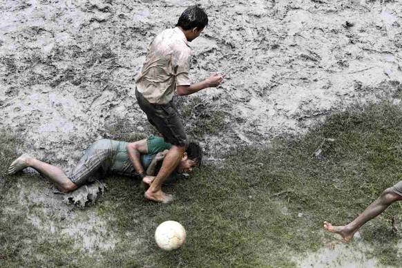 Indian boys play soccer in the mud in Calcutta, India, Sunday, June 13, 2010. (AP Photo/Bikas Das)