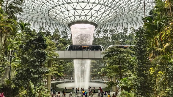 RECORD DATE NOT STATED The inside look of the Changi airport surrounded by tropical plants with a fountain from the ceiling *** der innen blicken des der Changi Flughafen umgeben indem tropisch Pflanz ...