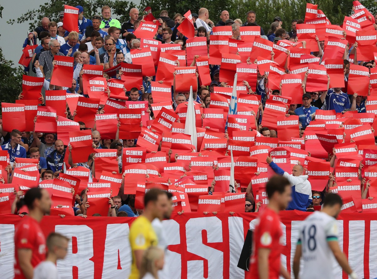 epa07766291 Schalke's supporters demonstrate against Racism and Clemes Toennies before the German DFB Cup 1st round match between SV Drochtersen/Assel and FC Schalke 04 in Drochtersen, Germany, 1 ...