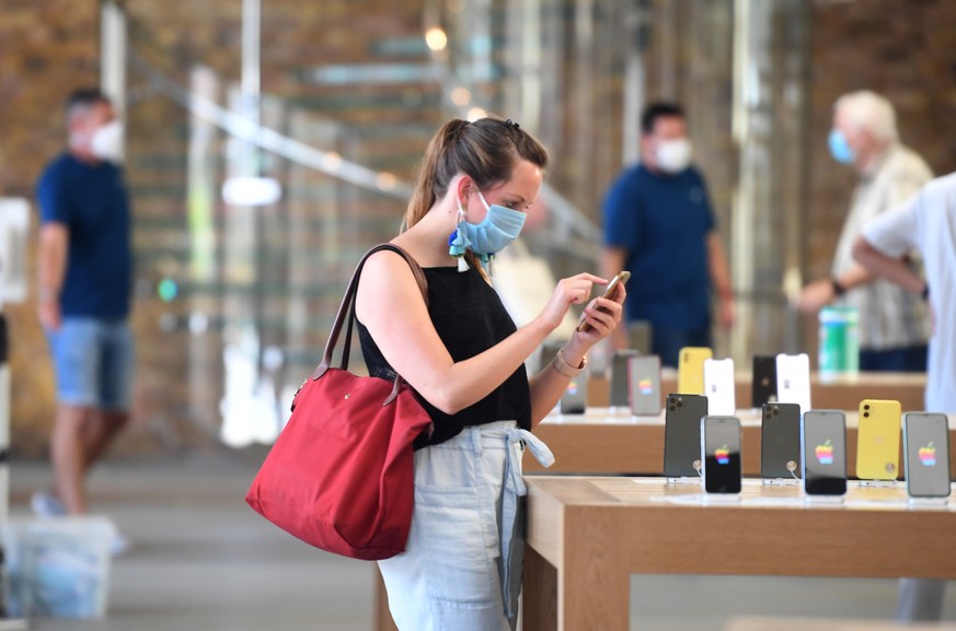 epa08486357 A customer in the Apple the store in Covent garden after opening its doors in London, Britain, 15 June 2020. Retail stores have begun to re-open their doors across the UK after three month ...