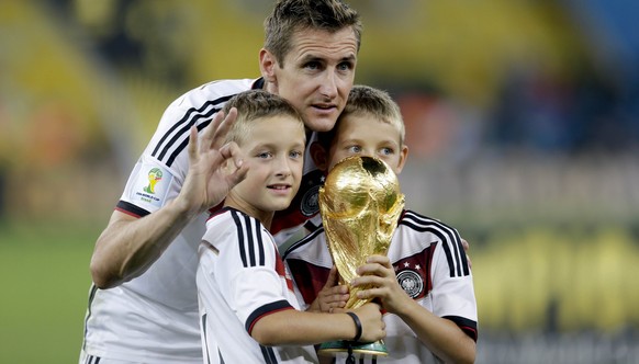 FILE - The July 13, 2014 file photo shows Germany&#039;s Miroslav Klose posing with the World Cup trophy and his sons following their 1-0 victory over Argentina after the World Cup final soccer match  ...
