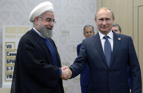 Russian President Vladimir Putin, right, shakes hands with President of the Islamic Republic of Iran Hassan Ruhani in Ufa, Russia, Thursday, July 9, 2015. (Alexander Nemenov/Pool photo via AP)