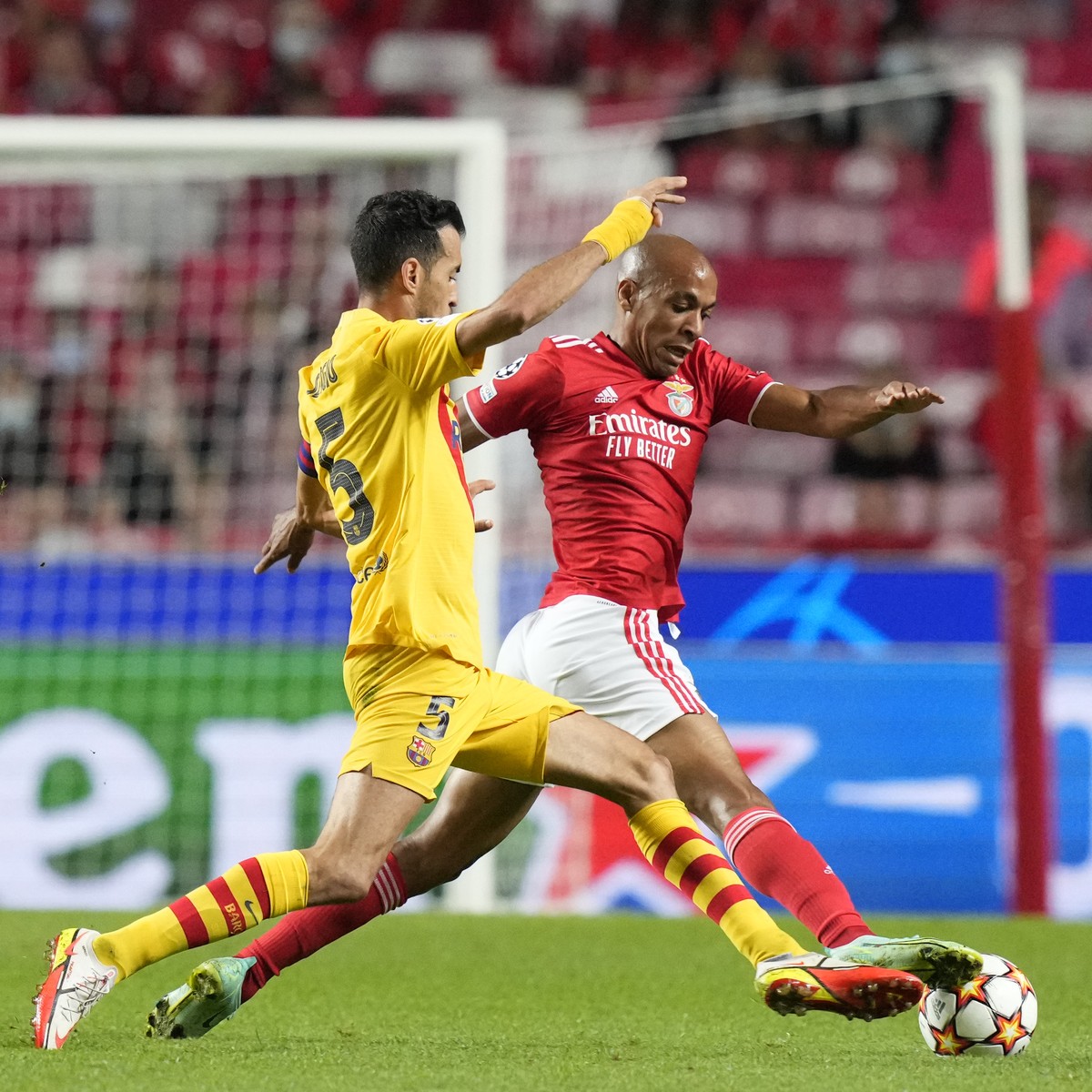 Benfica's Joao Mario, right is challenged by Barcelona's Sergio Busquets during a Group E Champions League soccer match between Benfica and Barcelona at the Luz stadium in Lisbon, Portugal,  ...