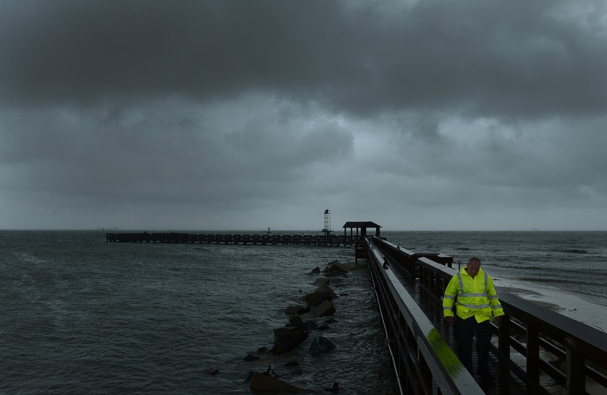 Cape Charles Police Department&#039;s Tom Potts walks back to his vehicle after checking out the fishing pier at Cape Charles, Va. on Saturday, Sept. 3, 2016. Tropical Storm Hermine lost hurricane str ...