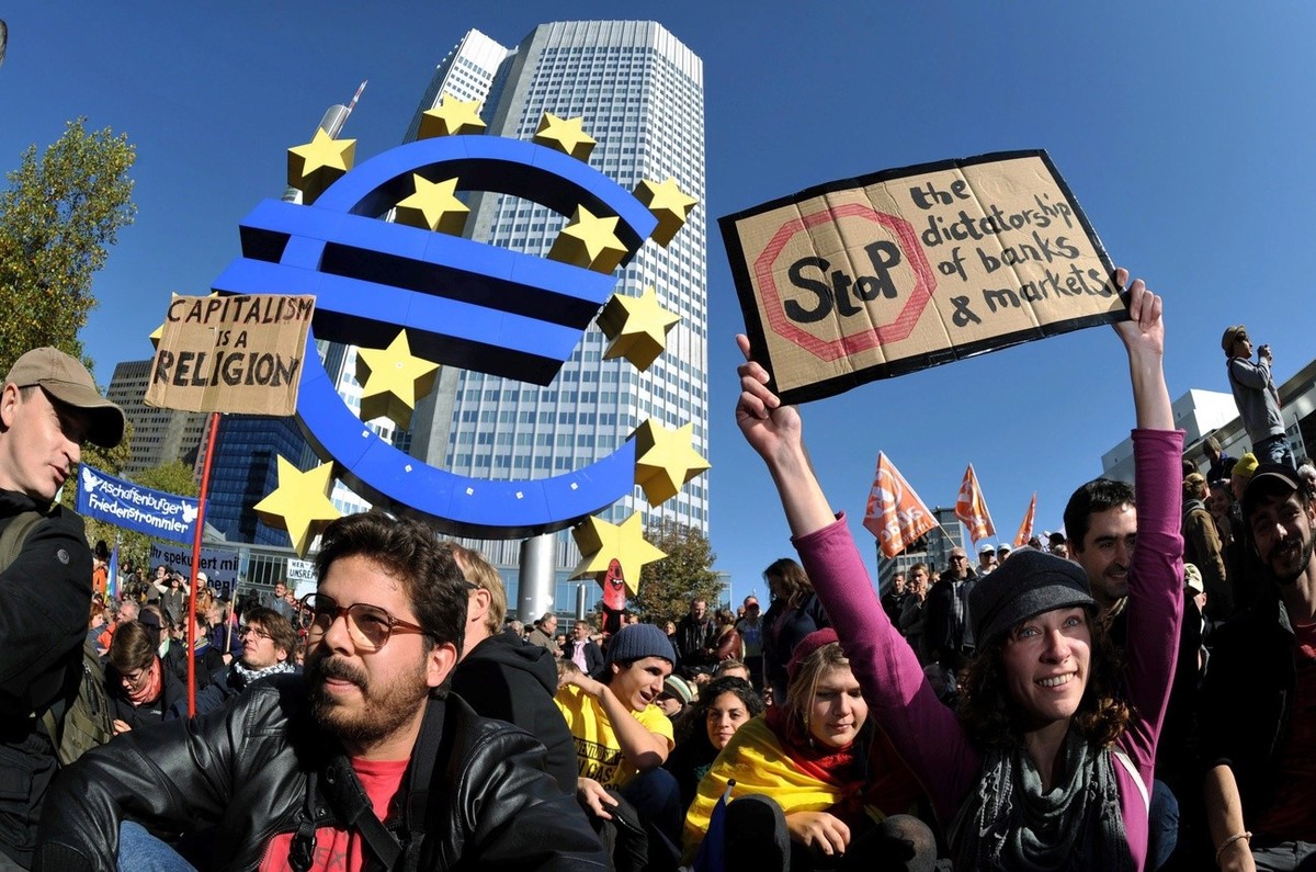 epa02967473 People protest against structures of the current global financial system with posters in front of the European Central Bank (ECB) in Frankfurt Main, Germany, 15 October 2011. The demonstra ...