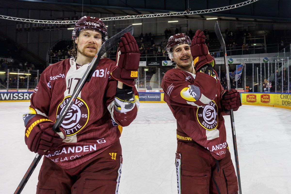 Geneve-Servette's defender Marco Maurer, left, and Geneve-Servette's defender Roger Karrer, right, greet their supporters after defeating the team Kloten, during a National League regular se ...