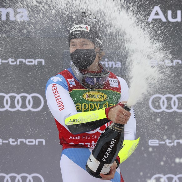 Switzerland's Marco Odermatt celebrates on the podium after winning the alpine ski World Cup men's giant slalom in Santa Caterina Valfurva, Italy, Monday, Dec. 7, 2020. (AP Photo/Alessandro  ...