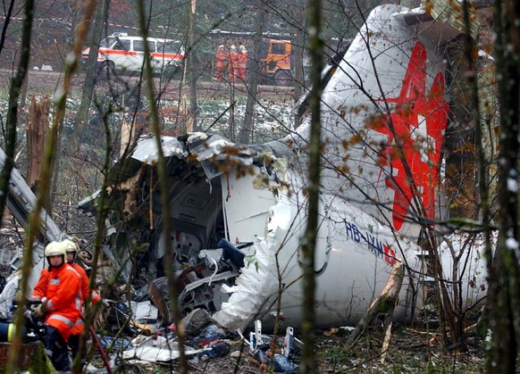 Rescue workers are seen next to the wreckage of the Crossair jet, Sunday Nov. 25, 2001, at the crash site in Birchwil, Switzerland. The Jumbolino jet by Swiss Crossair crashed late Saturday during its ...