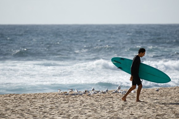 epa09001050 A surfer leaves the water at Bronte Beach in Sydney, New South Wales, Australia, 10 February 2021. EPA/PAUL BRAVEN AUSTRALIA AND NEW ZEALAND OUT