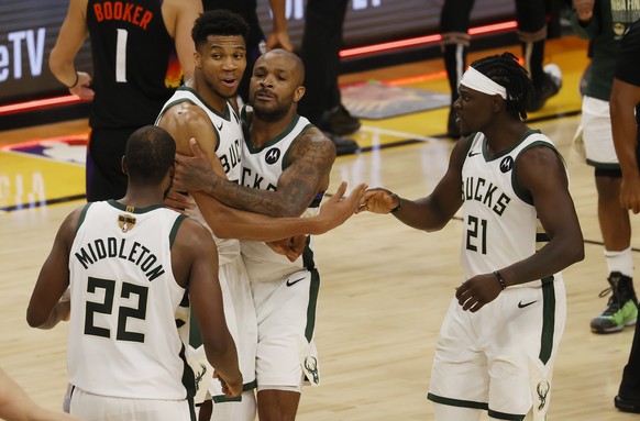 epa09351419 Milwaukee Bucks (L-R) Khris Middleton, Giannis Antetokounmpo, P.J. Tucker and Jrue Holiday celebrate after defeating the Phoenix Suns in game 5 of 2021 NBA Finals basketball playoff series ...