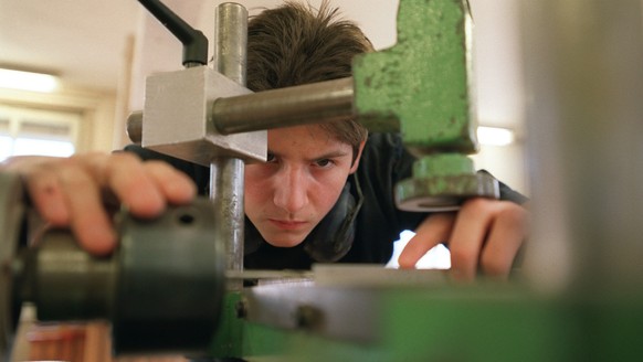 Ein Lehrling bei der Arbeit an der Maschine im Unterricht an der Abteilung Lehrwerkstaette fuer Moebelschreiner an der baugewerblichen Berufsschule Zuerich, aufgenommen am 4. Maerz 2003. (KEYSTONE/Gae ...