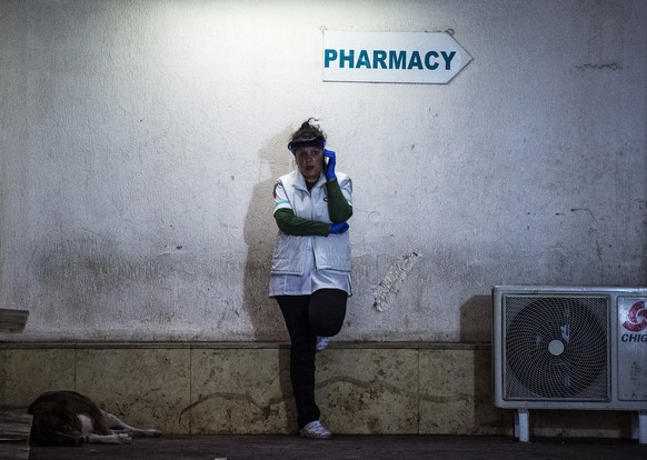 epa08311471 A pharmaceutical worker wearing a protective face mask stands in a street in Sofia, Bulgaria, 21 March 2020. Bulgaria is in state of emergency since 16 March 2020, as officially confirmed  ...