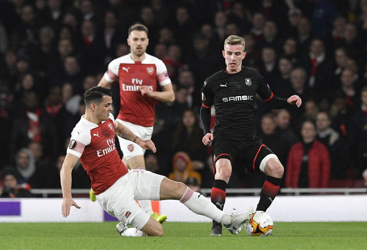 epa07437657 Arsenal's Granit Xhaka (L) tackles Stade Rennes's Benjamin Bourigeaud (R) during the UEFA Europa League soccer match between Arsenal and Stade Rennes at the Emirates Stadium in L ...