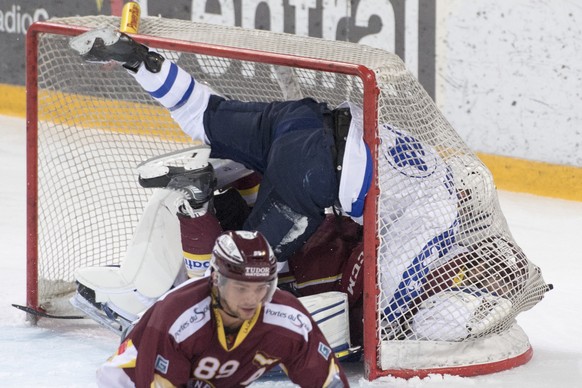 Johann Morant, links, von Zug, Daniel Rubin, 
Mitte, von Servette, und der Zuger Torhueter Tobias Stephan, rechts, fliegen zusammen ins Netz feiern das 1:2 beim Eishockey Meisterschaftsspiel zwischen  ...