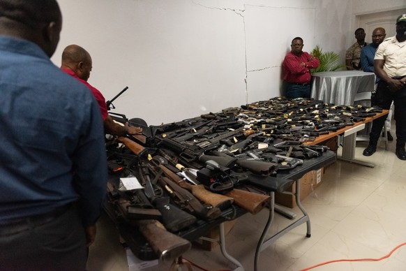 epa09936911 Haitian policemen display firearms they have seized in operations carried out in the neighborhoods of the capital controlled by the gangs, in Port-au-Prince, Haiti, 09 May 2022. Since last ...