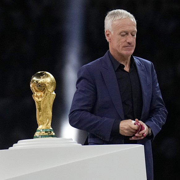 France's head coach Didier Deschamps walks past the trophy after receiving his second place medal at the end of the World Cup final soccer match between Argentina and France at the Lusail Stadium ...