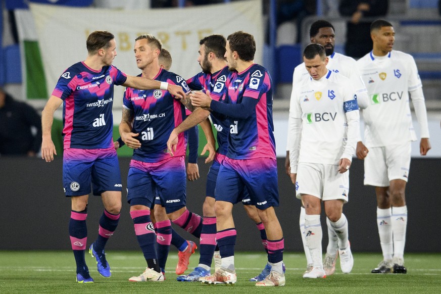 Le defenseur luganais Reto Ziegler, deuxieme depuisn la gauche, celebre son but sur penalty avec ses coequipiers devant la deception des lausannois, droite, lors de la rencontre de football de Super L ...