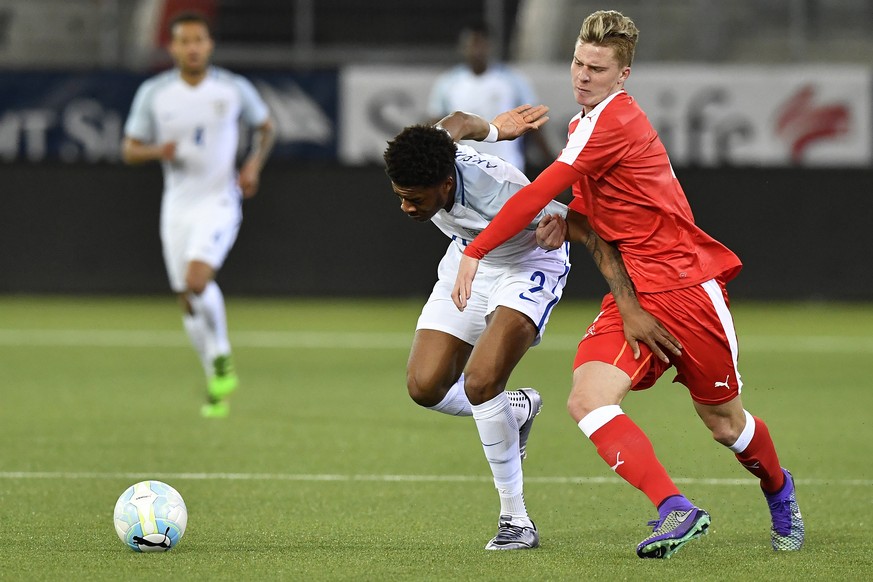 Switzerland&#039;s Nico Elvedi, right, fights for the ball with England&#039;s Chuba Akpom during the UEFA U21 Euro qualifier soccer match between Switzerland and England at the Stockhorn Arena in Thu ...