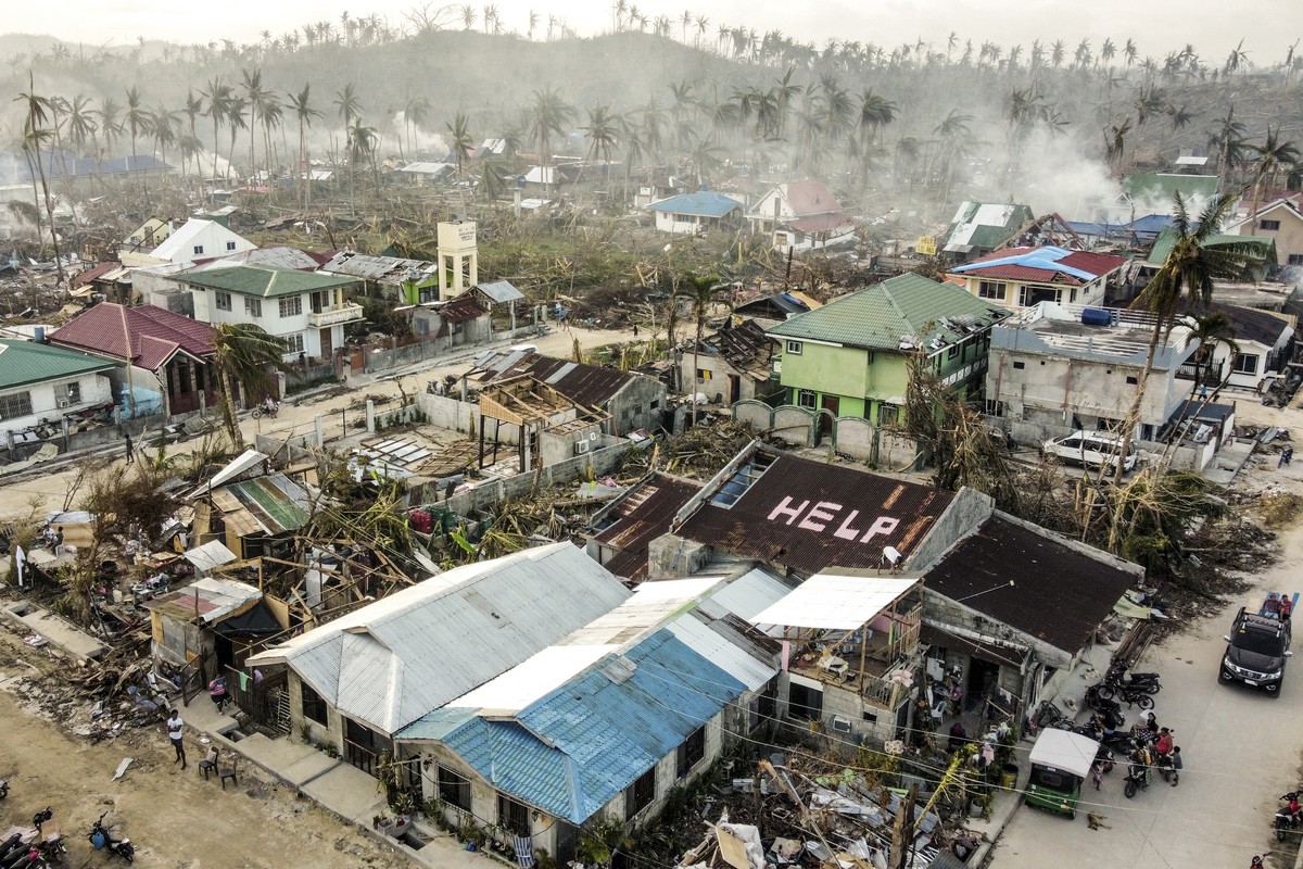A 'help' sign is painted on the roof beside damaged homes caused by Typhoon Rai in Siargao island, Surigao del Norte, southern Philippines on Wednesday, Dec. 22, 2021. Number of deaths conti ...