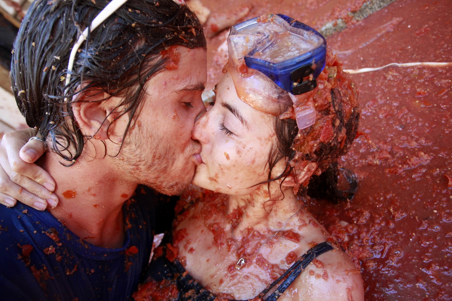 Revelers kiss each other during the annual "Tomatina" tomato fight fiesta in the village of Bunol, near Valencia, Spain, Wednesday, Aug. 29, 2012. Bunol's town hall estimated more than ...