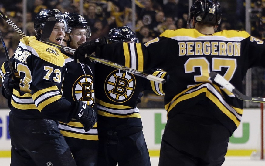 Boston Bruins center Patrice Bergeron (37) joins the celebration of a goal by right wing David Pastrnak, second from left, along with defenseman Charlie McAvoy (73) and left wing Brad Marchand (63) du ...