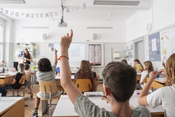 Primarschueler der Klasse 6a der Schule Laubegg strecken nach einer Frage, am ersten Tag des neuen Schuljahres, am Monatg, 11. Augsut 2025, in Bern. (KEYSTONE/Til Buergy).