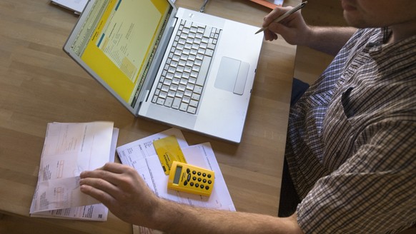 A man pays his bills via Postfinance&#039;s online portal in his flat in Winterthur in the canton of Zurich, Switzerland, pictured on February 5, 2009. (KEYSTONE/Alessandro Della Bella) 

Ein Mann bez ...