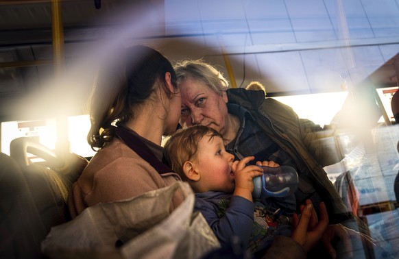 FILE - People with children wait after arriving from the Ukrainian city of Mariupol at a center for displaced people in Zaporizhzhia, Ukraine, May 3, 2022. With the evacuation of some civilians from a ...