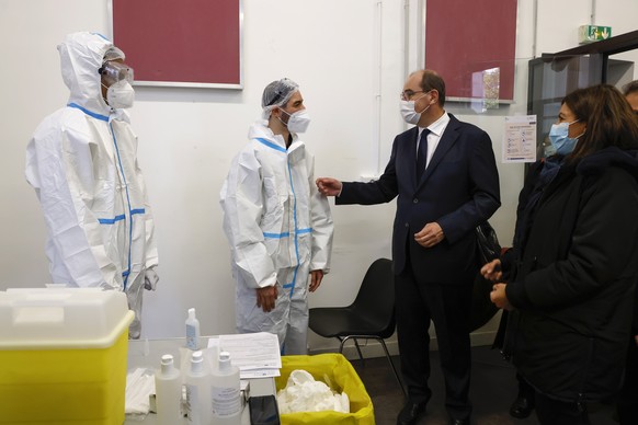 epa08748379 French Prime Minister Jean Castex (2-R) and Mayor of Paris Anne Hidalgo (R) meet with medical staff at a COVID-19 test centre located in the former 4th district City Hall in Paris, 15 Octo ...