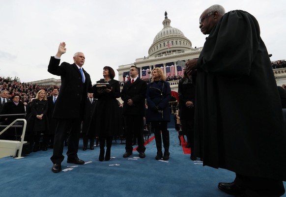 U.S. Vice President Mike Pence takes the oath of office as his wife Karen, son Michael and daughter Charlotte look on as U.S. Supreme Court Justice Clarence Thomas (R) administers the oath during inau ...