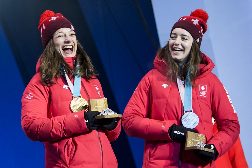 Gold medal winner Sarah Hoefflin of Switzerland, left, and Silver medal winner Mathilde Gremaud of Switzerland, right, celebrate during the victory ceremony on the Medal Plaza for the women Freestyle  ...