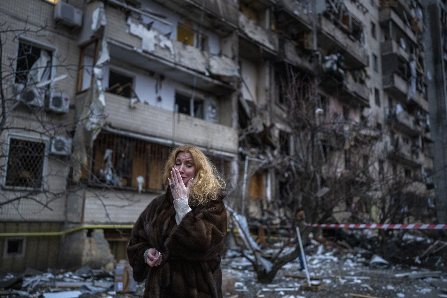 Natali Sevriukova reacts next to her house following a rocket attack the city of Kyiv, Ukraine, Friday, Feb. 25, 2022. (AP Photo/Emilio Morenatti)