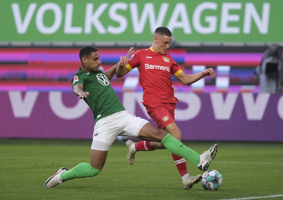 Wolfsburg's Maxence Lacroix, left, and Leverkusen's Florian Wirtz battle for the ball during the German Bundesliga soccer match between Wolfsburg and Bayer Leverkusen in the Volkswagen Arena ...