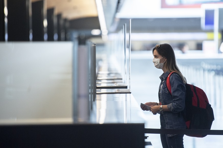 Fluggaeste warten mit Atemschutzmasken vor einem Check-In Schalter aufgenommen anlaesslich des Schutzkonzeptes vom Flughafen Zuerich, aufgenommen am Donnerstag, 28. Mai 2020 in Zuerich. (KEYSTONE/Enni ...