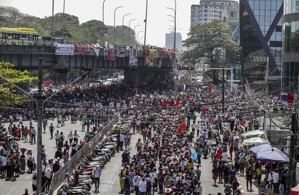 epa09017501 Demonstrators hold placards and banners calling for the release of detained Myanmar State Counselor Aung San Suu Kyi, as they block a road during a protest against the military coup, in Ya ...