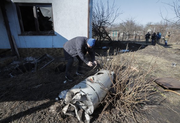 epa09826082 A local looks at the debris of a rocket following an overnight shelling on a holiday village in the Osokorky district, outskirts of Kyiv (Kiev), Ukraine, 15 March 2022. Kyiv authorities an ...