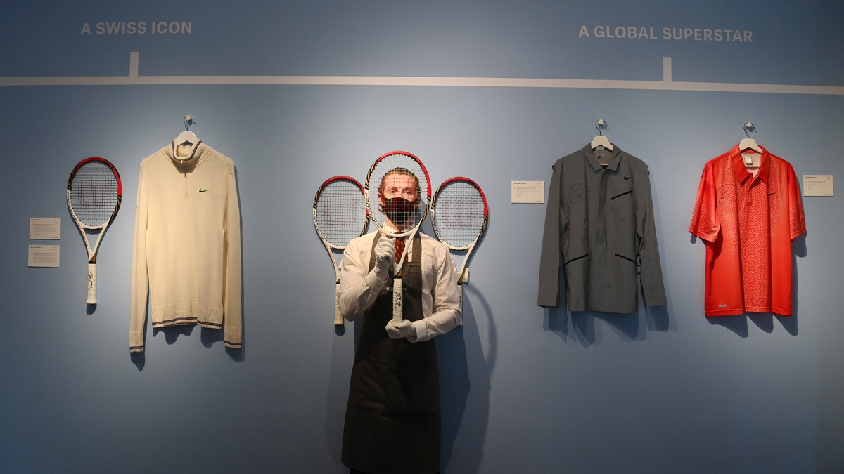 epa09290308 A Christie's employee poses with Swiss tennis Roger Federer's racket used at the London Olympics 2012 at the Christie's auction house, in London, Britain, 21 June 2021. An o ...