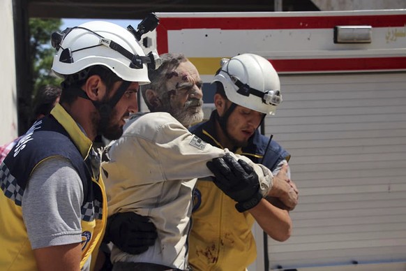 This photo provided by the Syrian Civil Defense White Helmets, which has been authenticated based on its contents and other AP reporting, shows members of the White Helmets carrying a man who was woun ...
