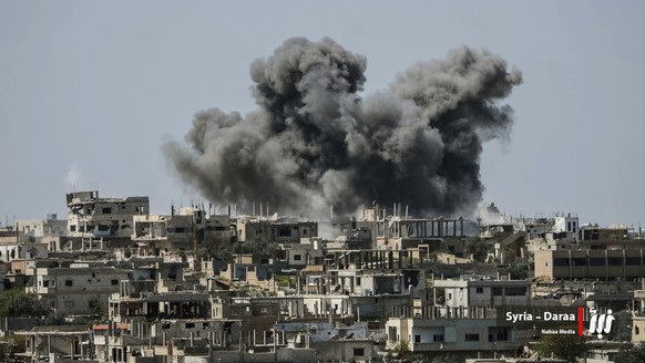 FILE - This Thursday, July 5, 2018 file photo provided by Nabaa Media, a Syrian opposition media outlet, shows smoke rising over buildings that were hit by Syrian government forces bombardment, in Dar ...