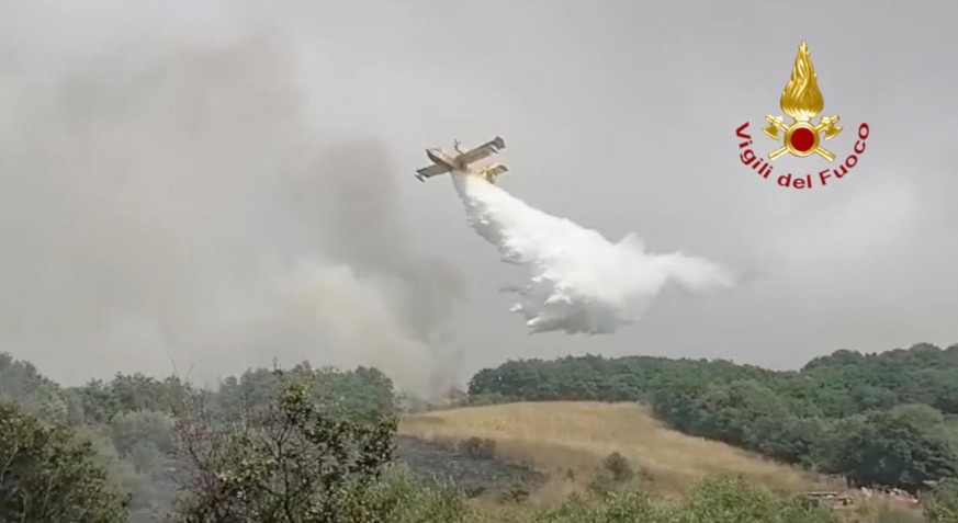 epa09366491 A handout photo made available by Vigili del Fuoco, the Italian National Fire Brigade, shows a firefighting aircraft dousing a fire burning in the province of Oristano, Sardinia Island, It ...