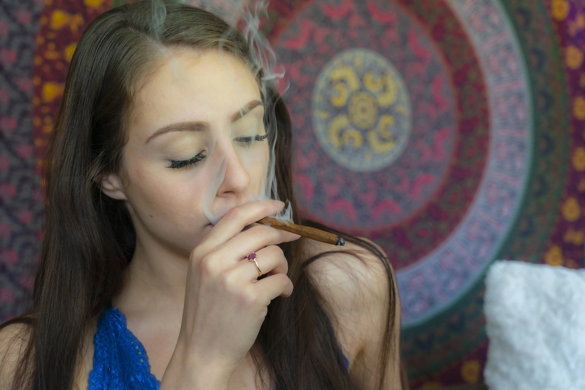 A beautiful brunette model smokes marijuana in the privacy of her own home model released