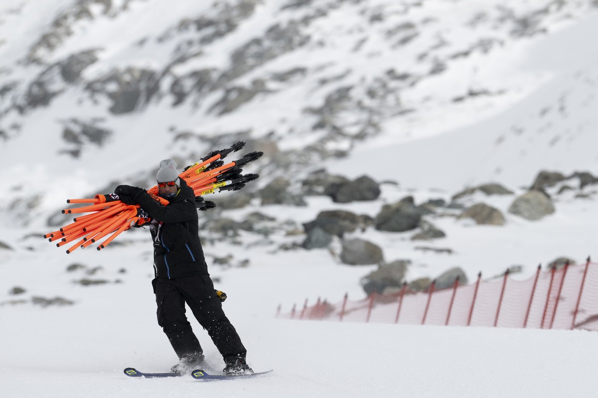 epa10984171 A worker removes gates after the women's downhill race was cancelled due to strong winds, on the new ski course "Gran Becca" at the Alpine Skiing FIS Ski World Cup Zermatt-C ...