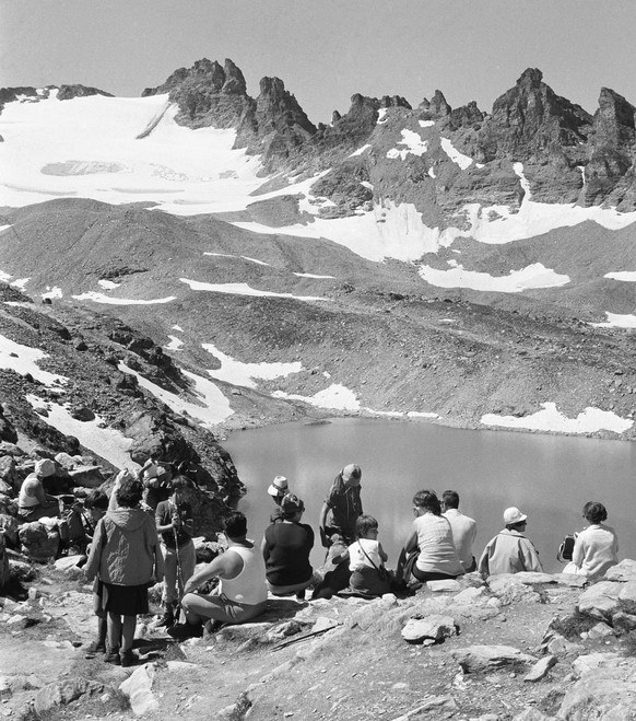 Hikers enjoy the view onto the peak at the Wildseeluecke on Mount Pizol in Switzerland on August 1, 1971. (KEYSTONE/PHOTOPRESS-ARCHIV/Roethlin)

Wanderer geniessen am 1. August 1971 an der Wildseeluec ...