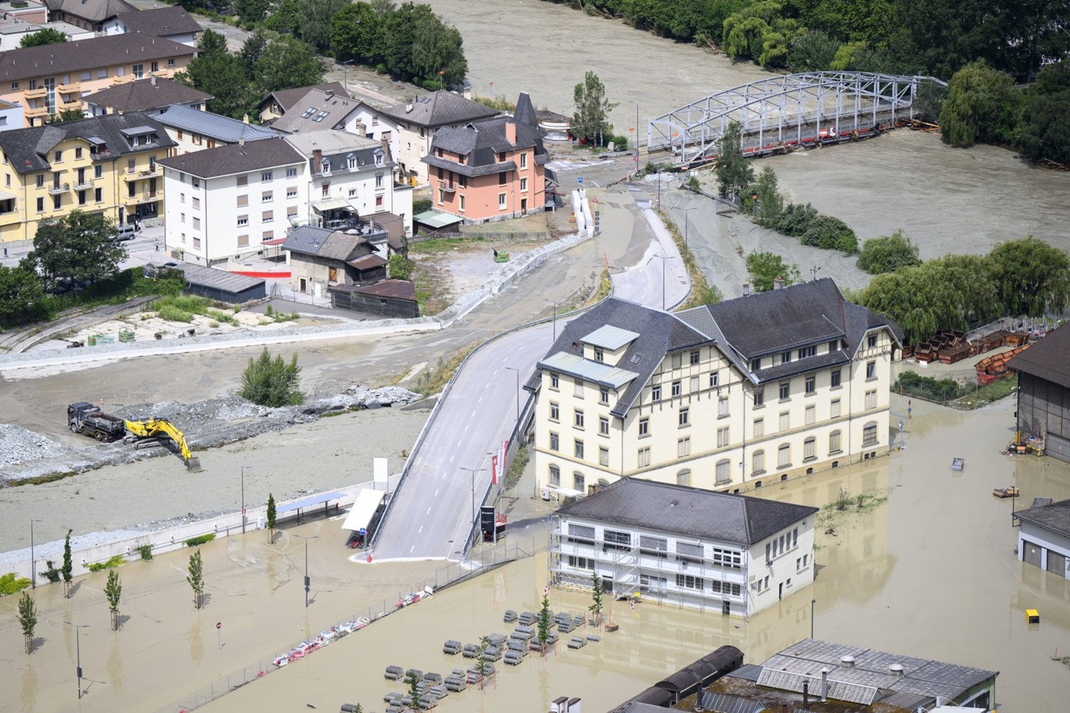 The Rhone River, right, and the Navizence river, left, are overflowing the industrial zone following the storms that caused major flooding, in Chippis, Switzerland, Sunday, June 30, 2024. (KEYSTONE/Je ...