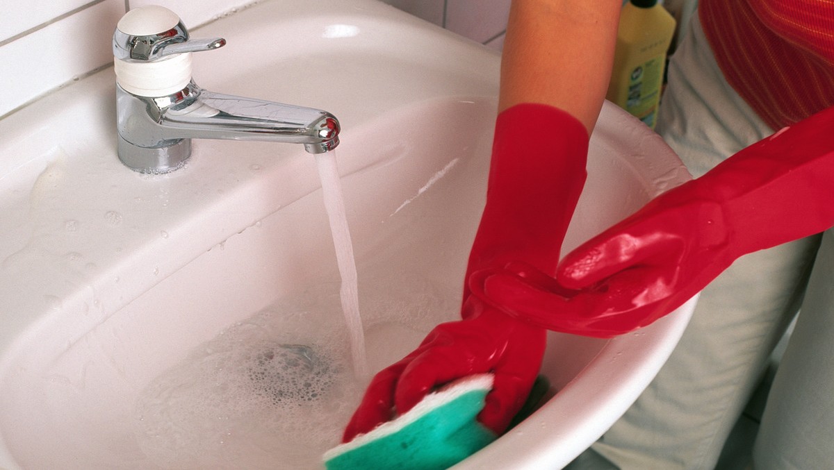 [Stockbild] Housework. Hausarbeit. Woman. Frau. Bathroom. Badezimmer. Lavabo. Waschbecken. Clean. Grooming. Putzen. Sponge. Schwamm. (KEYSTONE/Ayse Yavas) === , === : DIA, Nr. 156977]