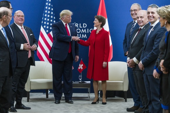 Swiss president Simonetta Sommaruga, right, shakes hands with US president Donald Trump, left, Swiss Federal Councillors Ignazio Cassis, Ueli Maurer and Guy Parmelin, from right, as well as the US ambassador to Switzerland, Edward McMullen, left, look on, during a bilateral meeting on the sidelines of the 50th annual meeting of the World Economic Forum, WEF, in Davos, Switzerland, Tuesday, January 21, 2020. (KEYSTONE/Alessandro della Valle)