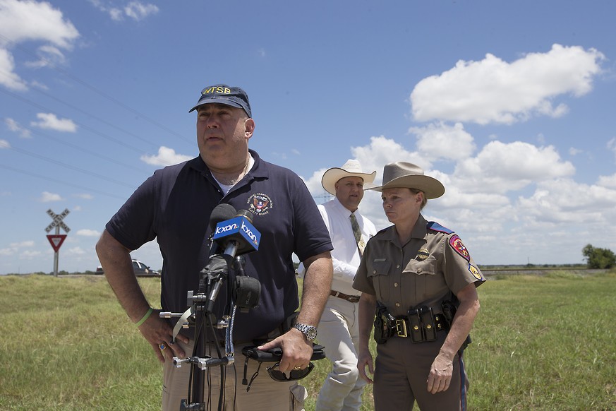 National Transportation Safety Board Senior Advisor Erik Grosof, left, Caldwell County Sheriff Daniel Law and Texas DPS Trooper Robbie Barrera, right, leave the scene of a hot air balloon disaster Sat ...