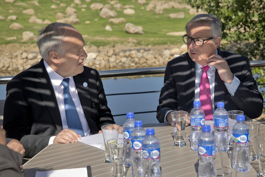 Switzerland&#039;s President Johann Schneider-Ammann, left, and European Commission President Jean-Claude Juncker, right, talk during a bilateral meeting at the 11th Asia-Europe Meeting (ASEM) in Ulaa ...