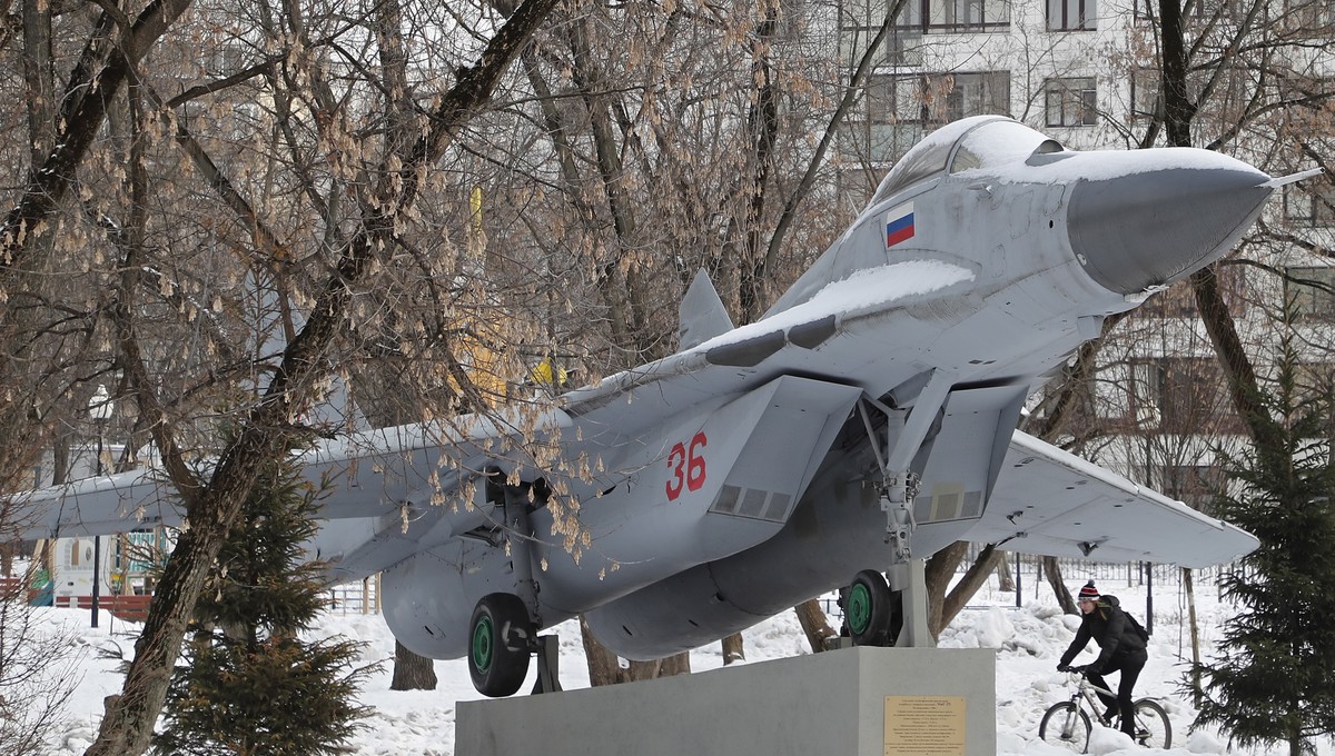 epa10454425 A man rides a bike next to a Soviet-made MiG-29 multirole fighter installed as a monument at the Fedora Poletayeva square in Moscow, Russia, 08 February 2023. Temperature in Moscow reached ...