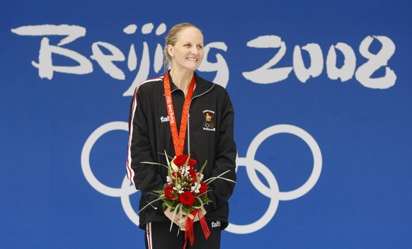 FILE - Zimbabwe's Kirsty Coventry smiles after receiving her gold medal after the women's 200-meter backstroke final during the swimming competitions in the National Aquatics Center at the B ...